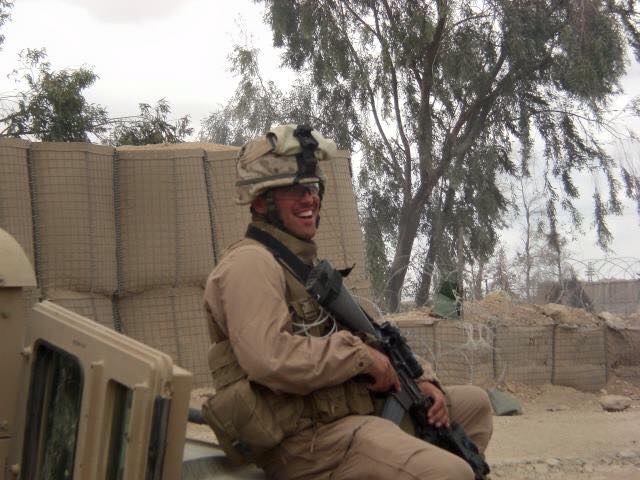 Picture of Patrick in full gear in Iraq, sitting on top of a Humvee.